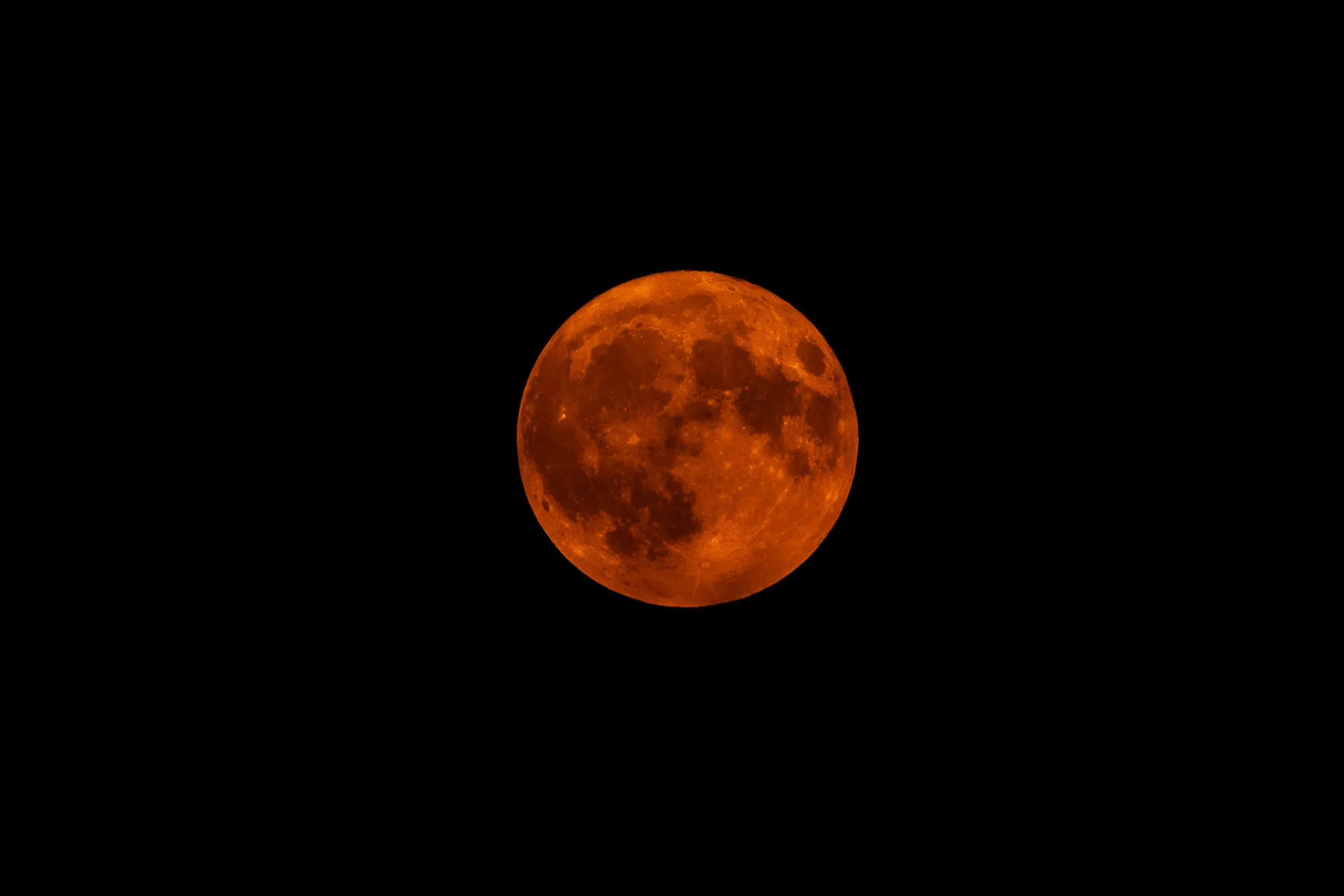 Tiefroter Vollmond vor schwarzem Nachthimmel