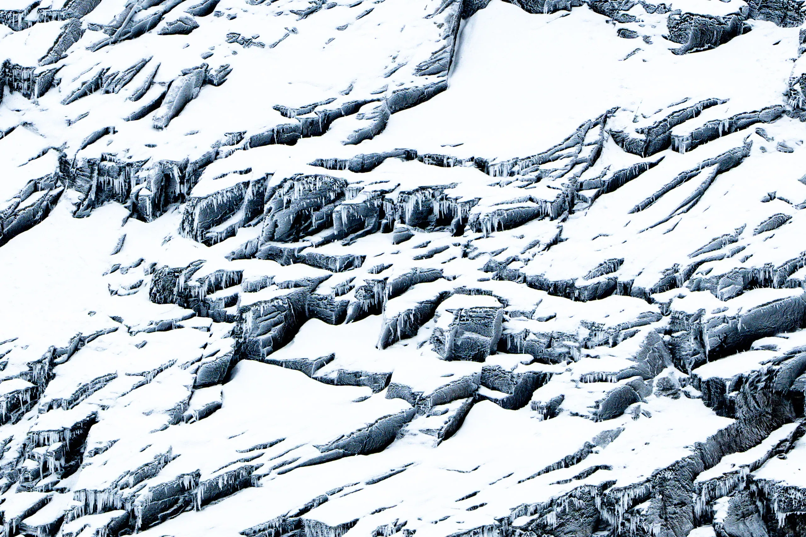 Abstrakte Struktur aus Schnee und Fels an einer Bergflanke