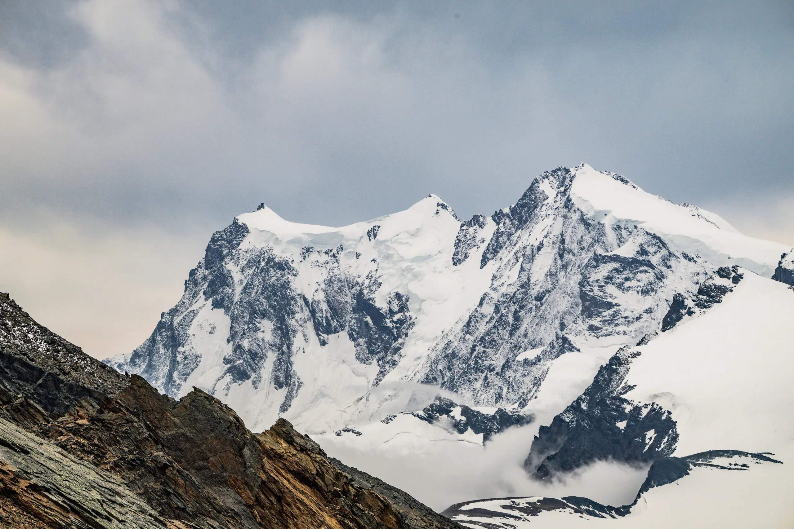 Schneebedeckte Gletschergipfel unter bewölktem Himmel