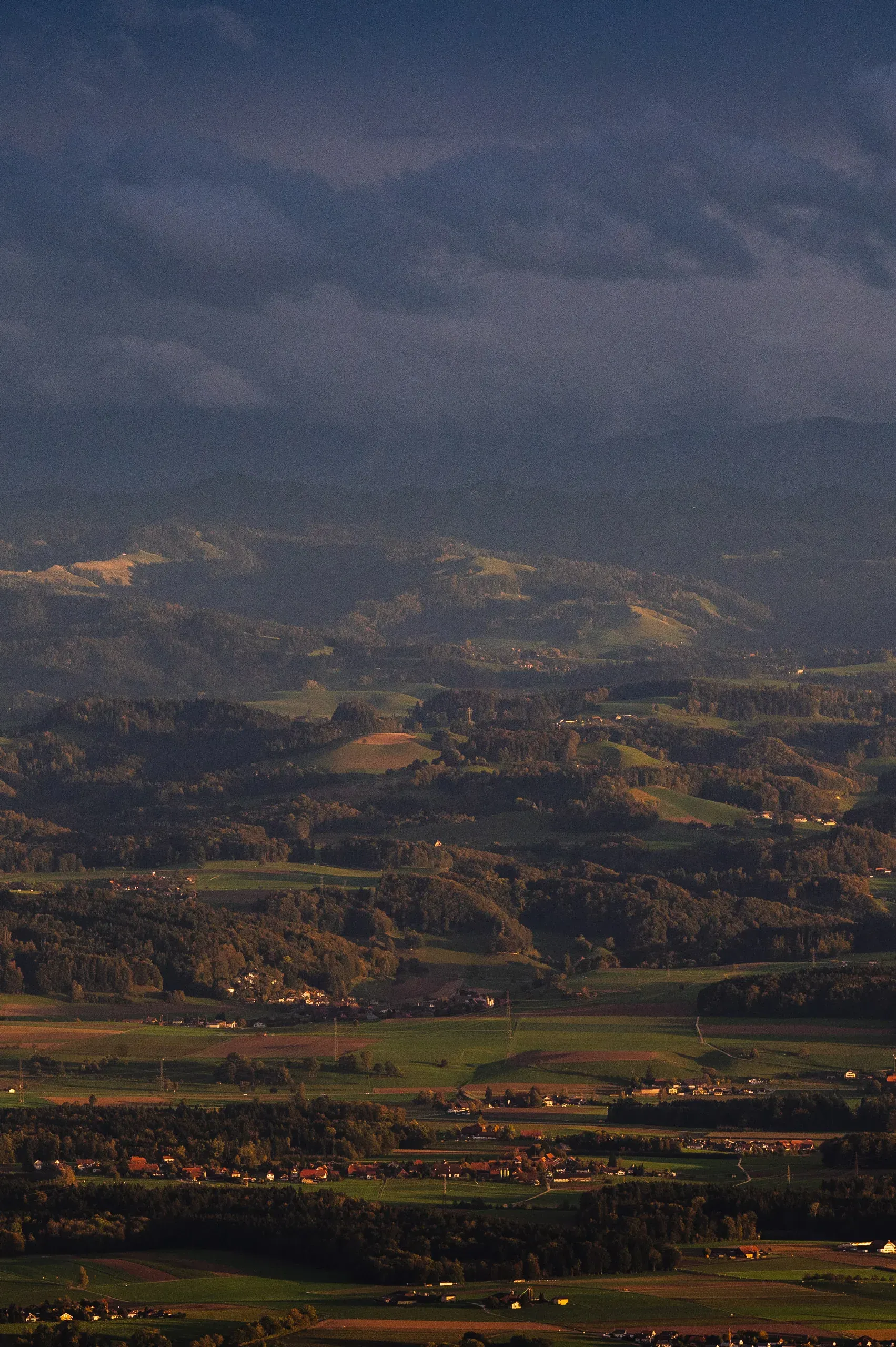 Weite Hügellandschaft unter dramatischem Wolkenlicht